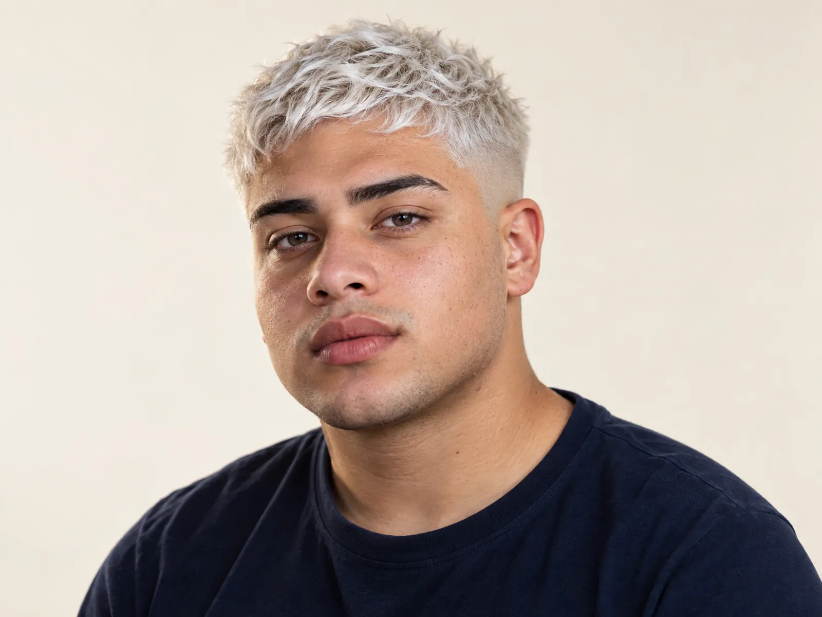 Hombre chileno con pelo platinado corto texturizado y raíz oscura apenas visible